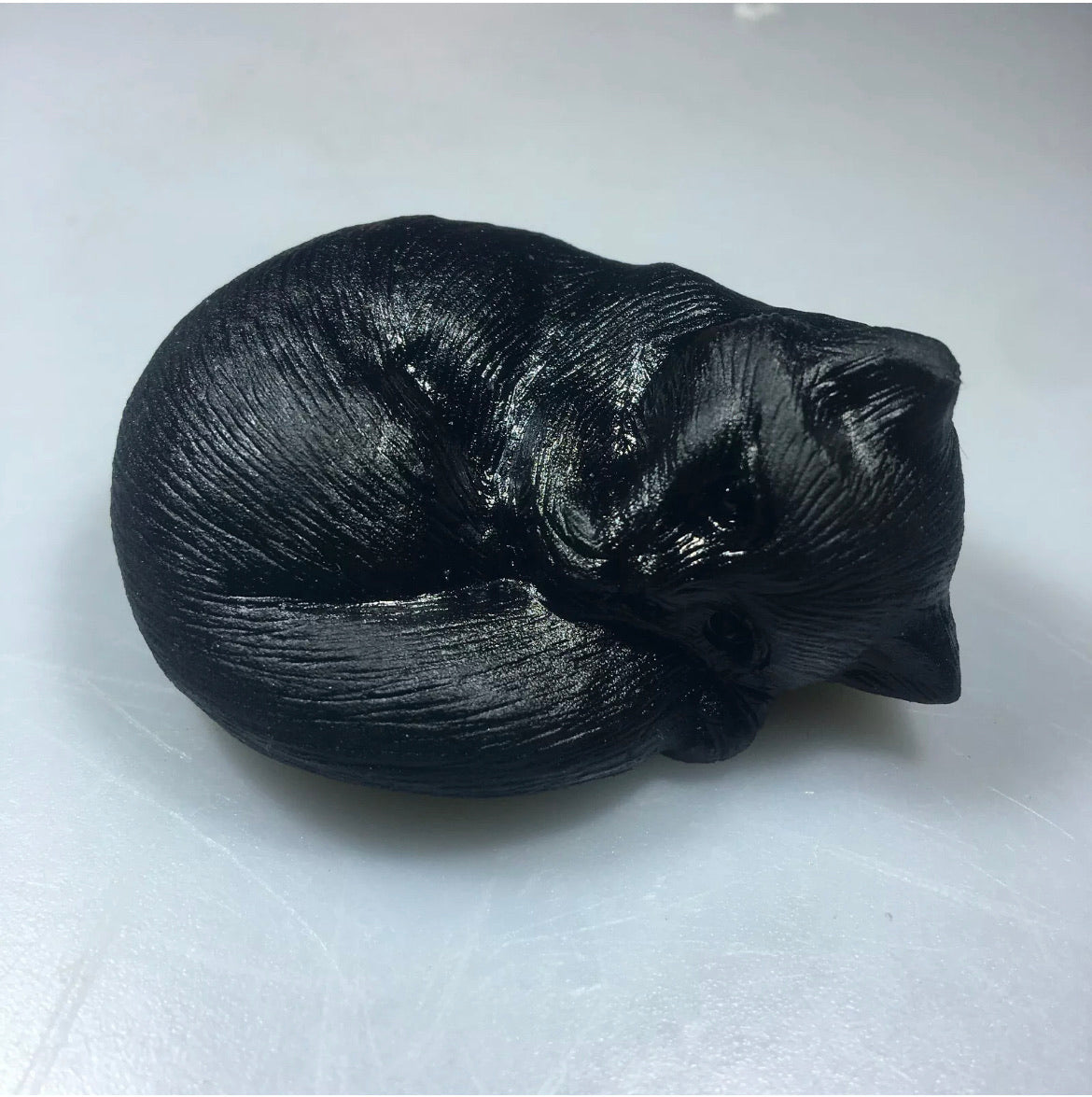 Black obsidian gemstone carved sleeping kitty cat