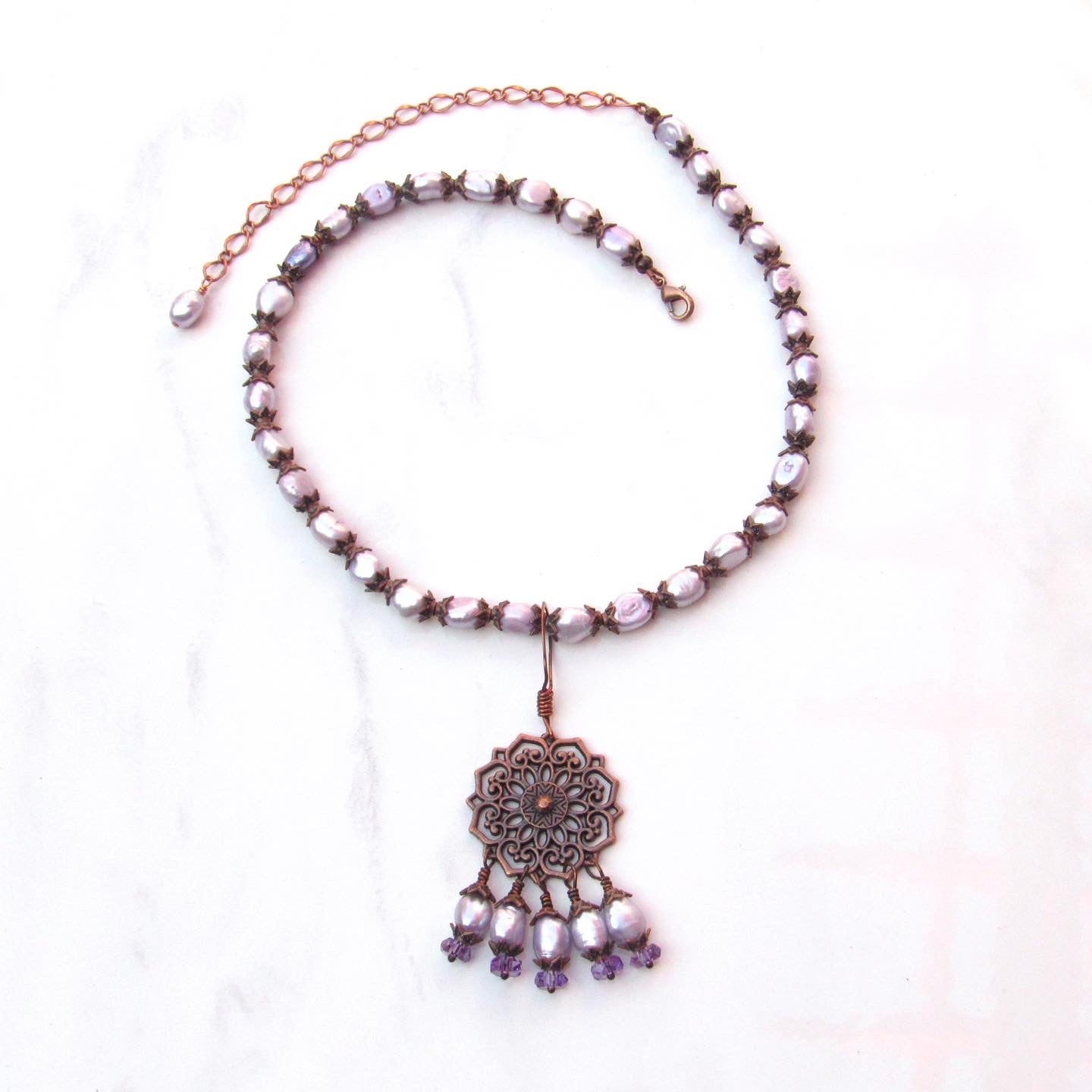 Purple freshwater pearls, amethyst gemstones, and copper chain and pendant design.